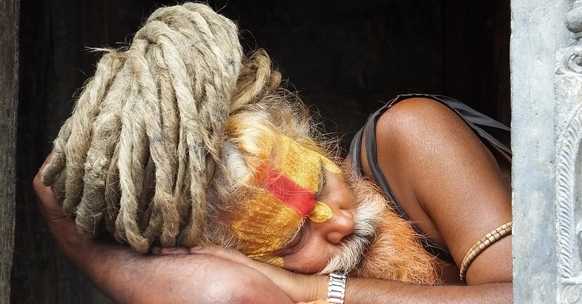 Sleeping Sadhu with painted face and dreadlocks