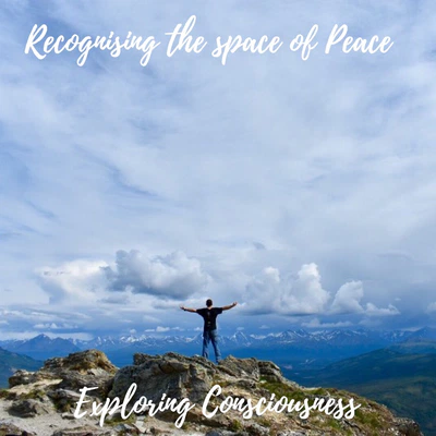 Man on mountain top, arms outstretched, peaceful view.